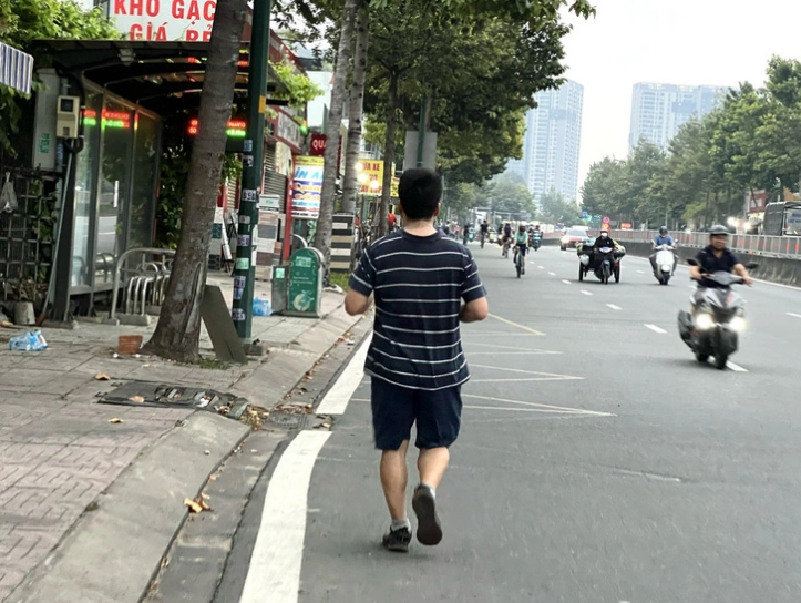 Another man runs in the opposite direction on Pham Van Dong Street. Photo: Xuan Doan / Tuoi Tre