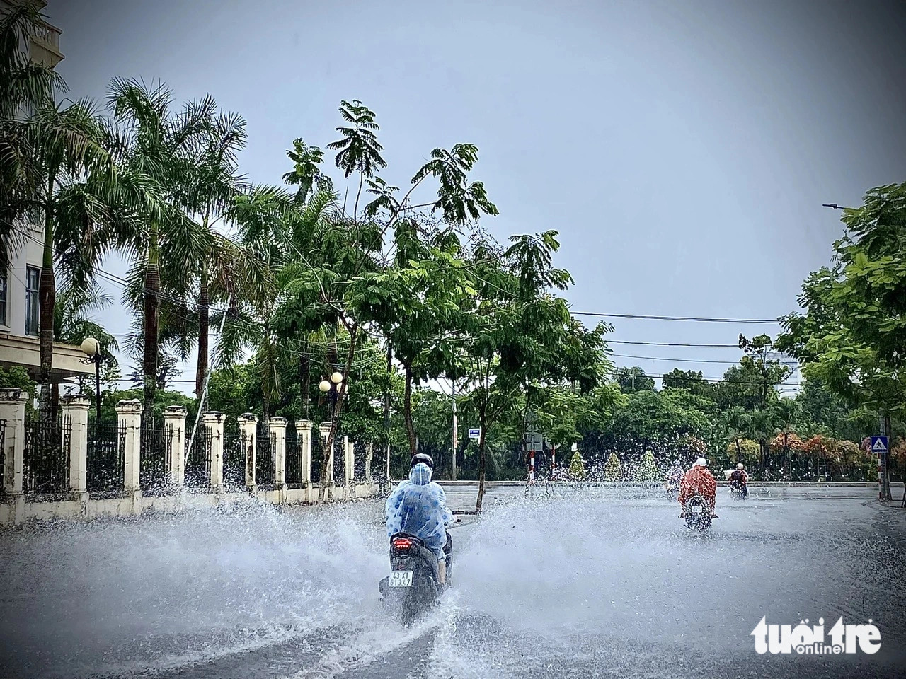 Commuters travel on a waterlogged street in Cam Le District, Da Nang City, central Vietnam. Photo: Truong Trung / Tuoi Tre