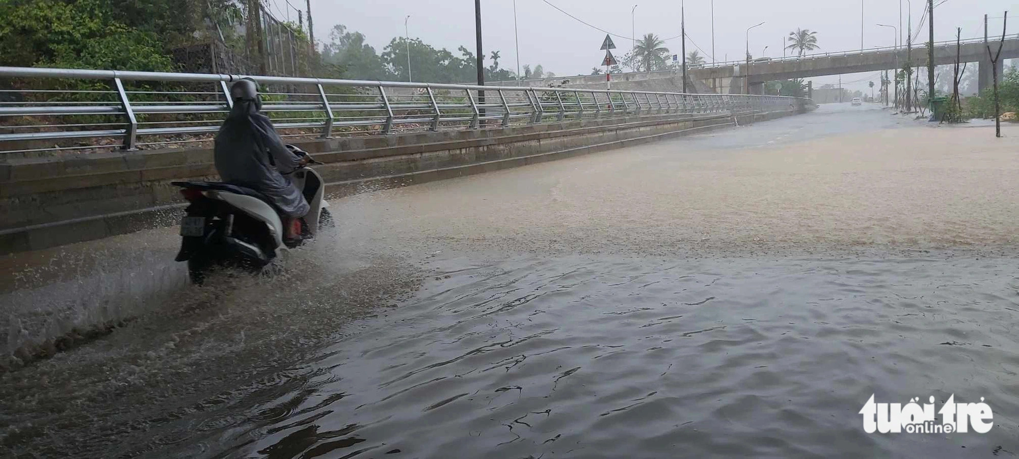 An inter-provincial road running through Hoa Vang District, Da Nang City, central Vietnam is submerged in nearly 40 centimeters of water. Photo: Doan Cuong / Tuoi Tre