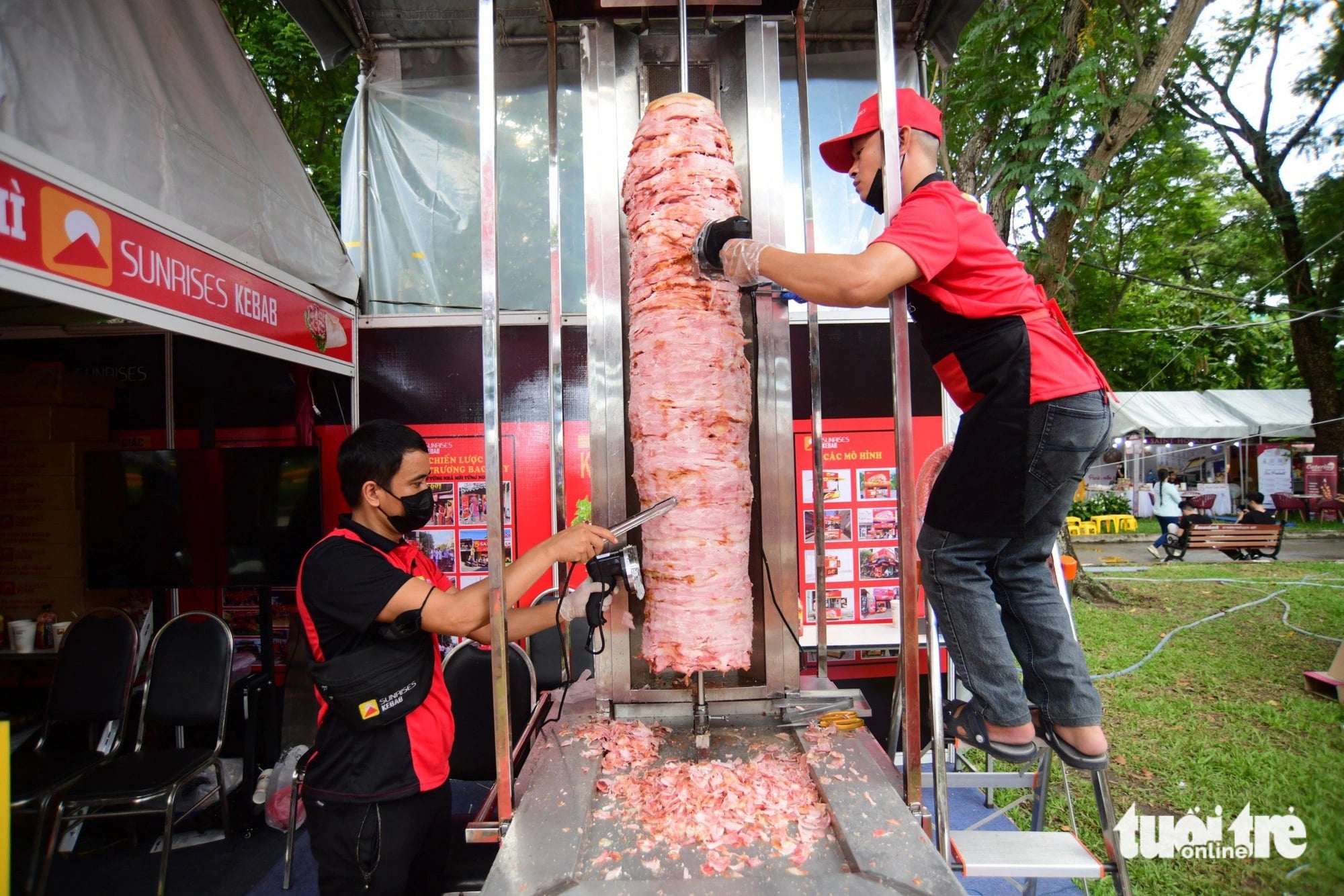 Staff works on a big kebab skewer at a booth at the Vietnam Banh Mi Festival at Le Van Tam Park in District 1, Ho Chi Minh City on May 17. Photo: Quang Dinh / Tuoi Tre