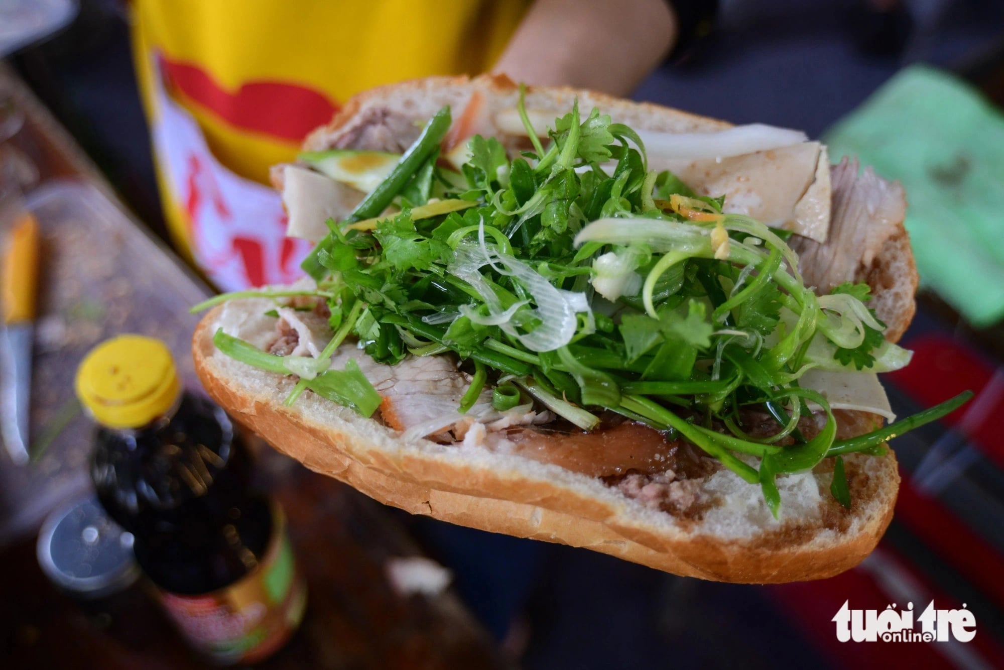 A loaf of Vietnamese ‘banh mi’ filled with pork, sauce and a lot of scallion and coriander is pictured at the Vietnam Banh Mi Festival at Le Van Tam Park in District 1, Ho Chi Minh City on May 17. Photo: Quang Dinh / Tuoi Tre