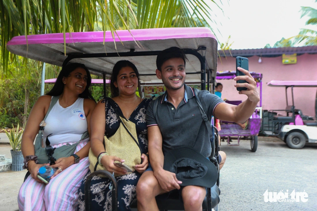 Paldo I. Tomi, a Chilean traveler, takes a wefie of himself and his companions during a trip by electric tourist car on Thoi Son Isle, an attractive destination on the Tien River in Tien Giang Province, southern Vietnam. Photo: Phuong Quyen / Tuoi Tre