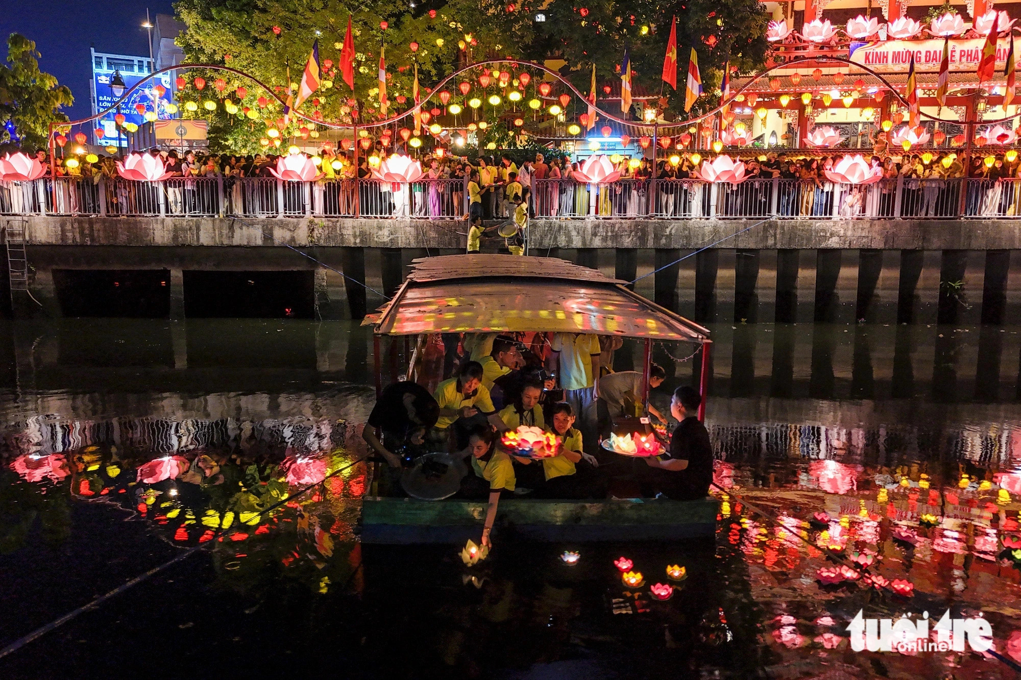 Volunteers assist local residents with releasing lanterns into the water. Photo: Phuong Quyen / Tuoi Tre