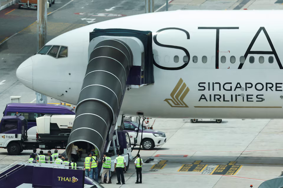 Airport officials gather near the aircraft ladder attached to the Singapore Airlines aircraft for flight SQ321 parked on the tarmac after an emergency landing at Suvarnabhumi International Airport, in Bangkok, Thailand, May 22, 2024. Photo: Reuters