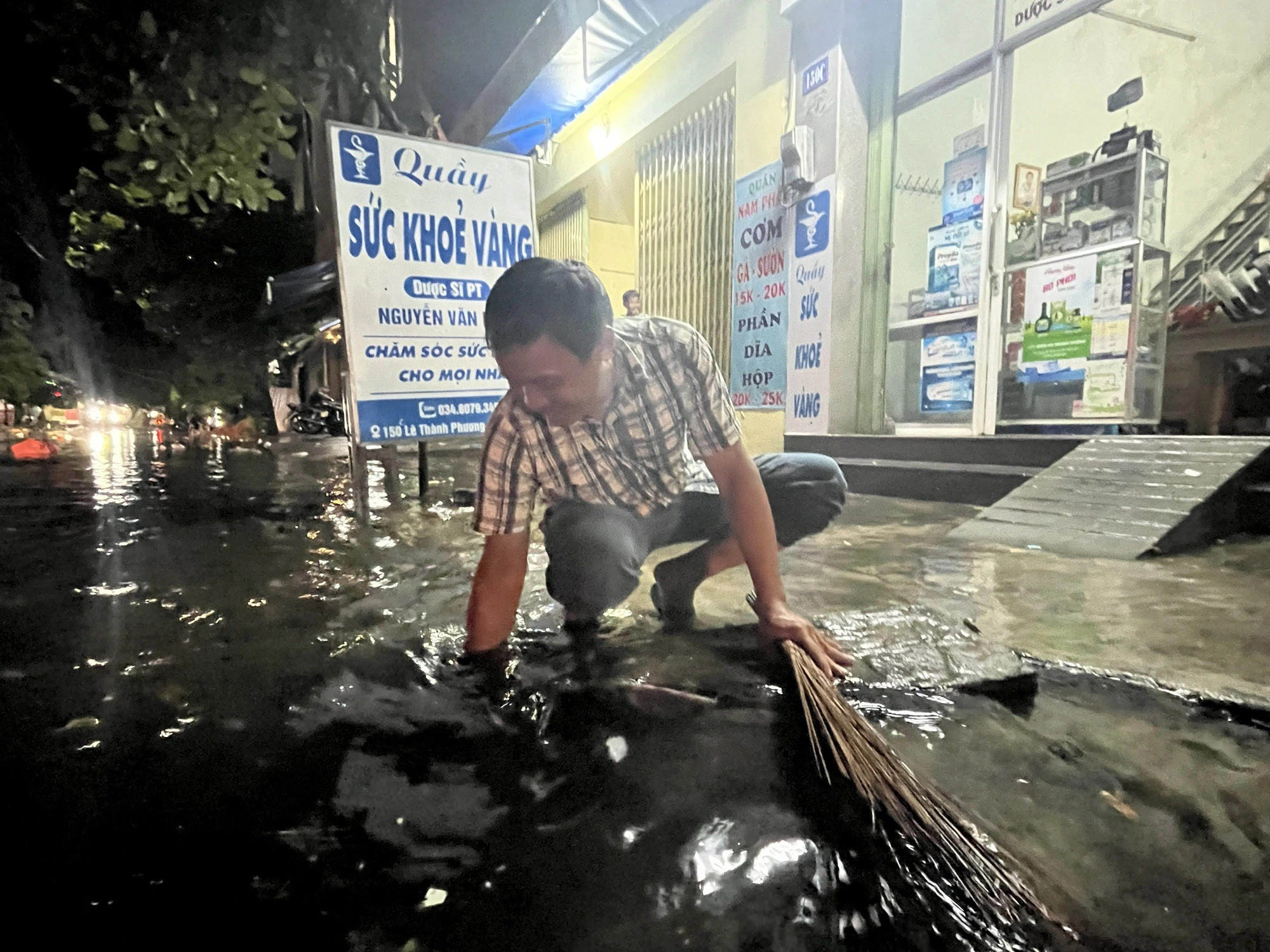 Another man removes trash from a manhole to help reduce inundation on Le Thanh Phuong Street in Tuy Hoa City under Phu Yen Province, central Vietnam, May 21, 2024. Photo: Nguyen Hoang / Tuoi Tre