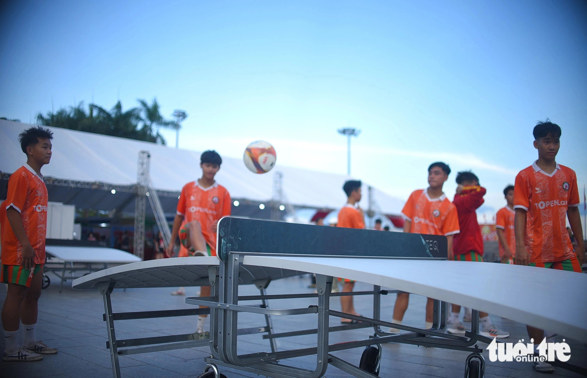 A group of teen boys play teqball on a curved table. Photo: Lam Thien / Tuoi Tre