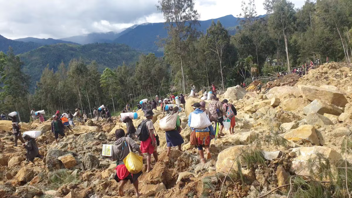 People carry bags in the aftermath of a landslide in Enga Province, Papua New Guinea, May 24, 2024, in this still image obtained from a video. Photo: Reuters