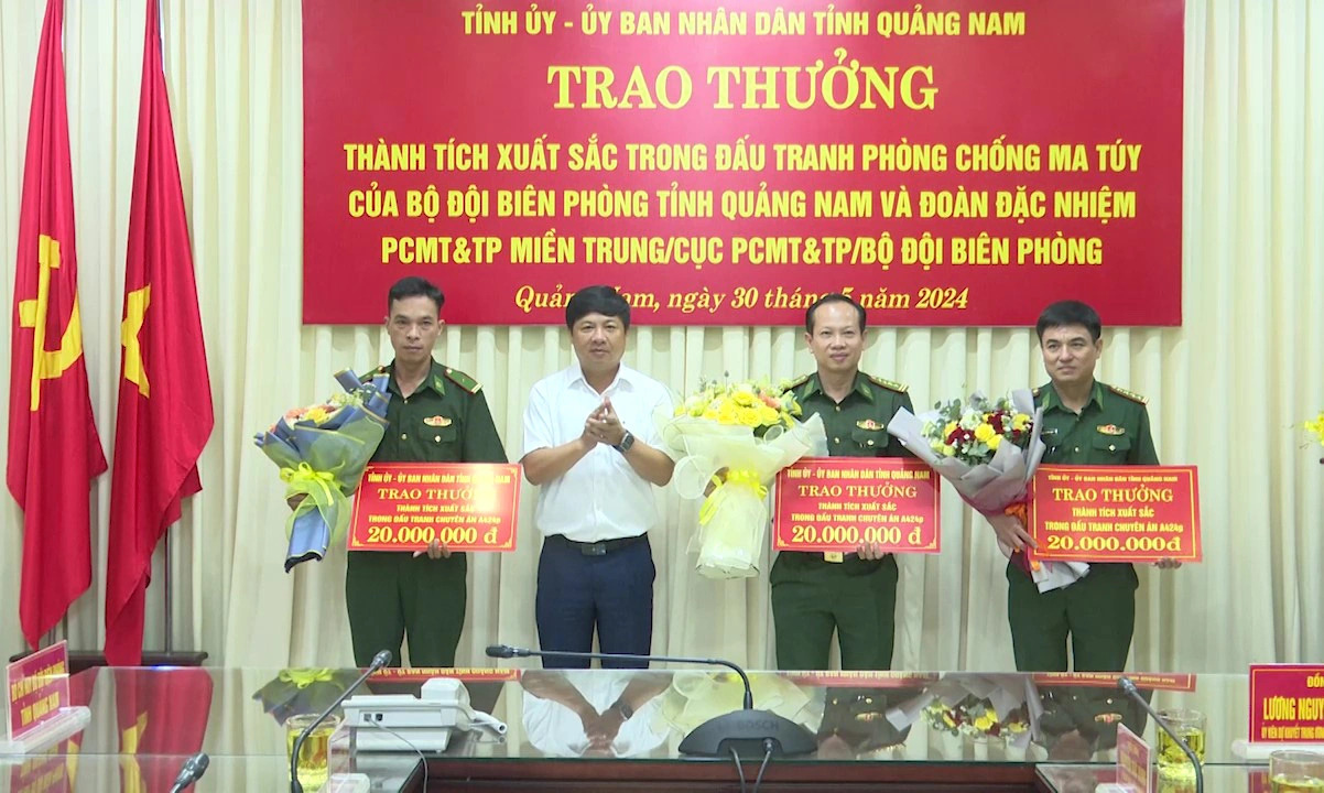 Luong Nguyen Minh Triet (L, 2nd), secretary of the Party Committee of Quang Nam Province, central Vietnam, awards flower bouquets and gifts to three border guard units for their great efforts to crack down an illegal drug ring. Photo: Supplied