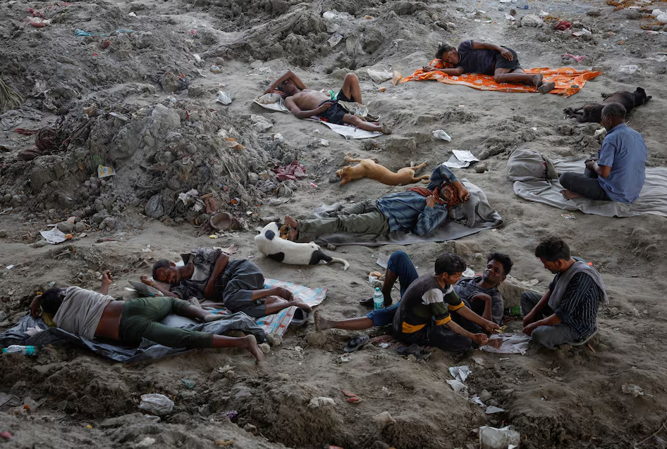 People rest on the Yamuna river bed under a bridge on a hot summer day in New Delhi, India, May 22, 2024. Photo: Reuters