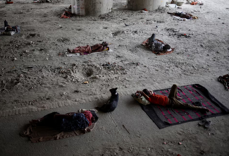 People sleep on the Yamuna river bed under a bridge on a hot summer day in New Delhi, India, May 22, 2024. Photo: Reuters