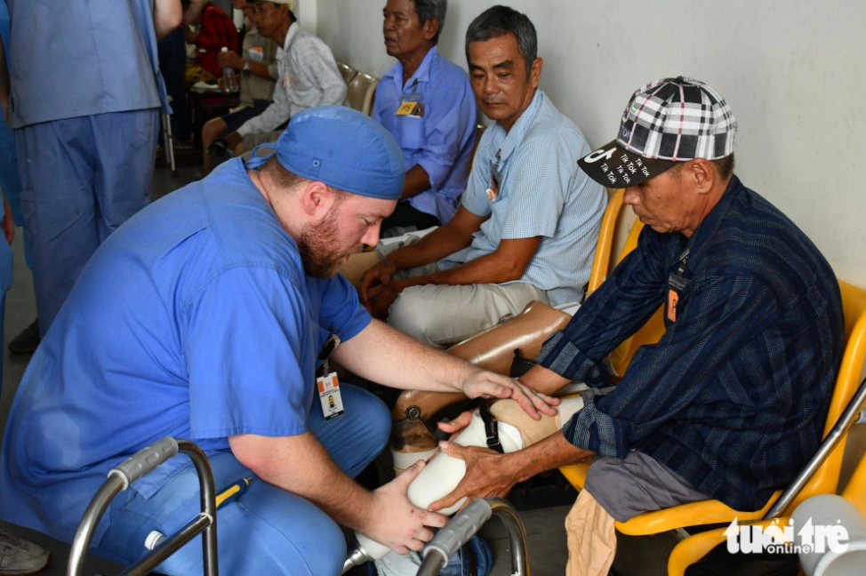 A foreign doctor fits a prosthetic leg to a disabled resident in Kien Giang Province, southern Vietnam. Photo: Buu Dau / Tuoi Tre