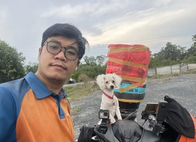 Nguyen Quoc Doanh often brings a dog as a friend on his way to work. Photo: Supplied