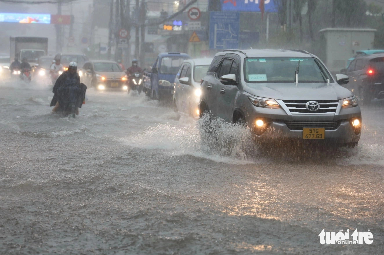 Vehicles wade through an inundated street in the rain in Ho Chi Minh City on May 31, 2024. Photo: Ngoc Quy / Tuoi Tre