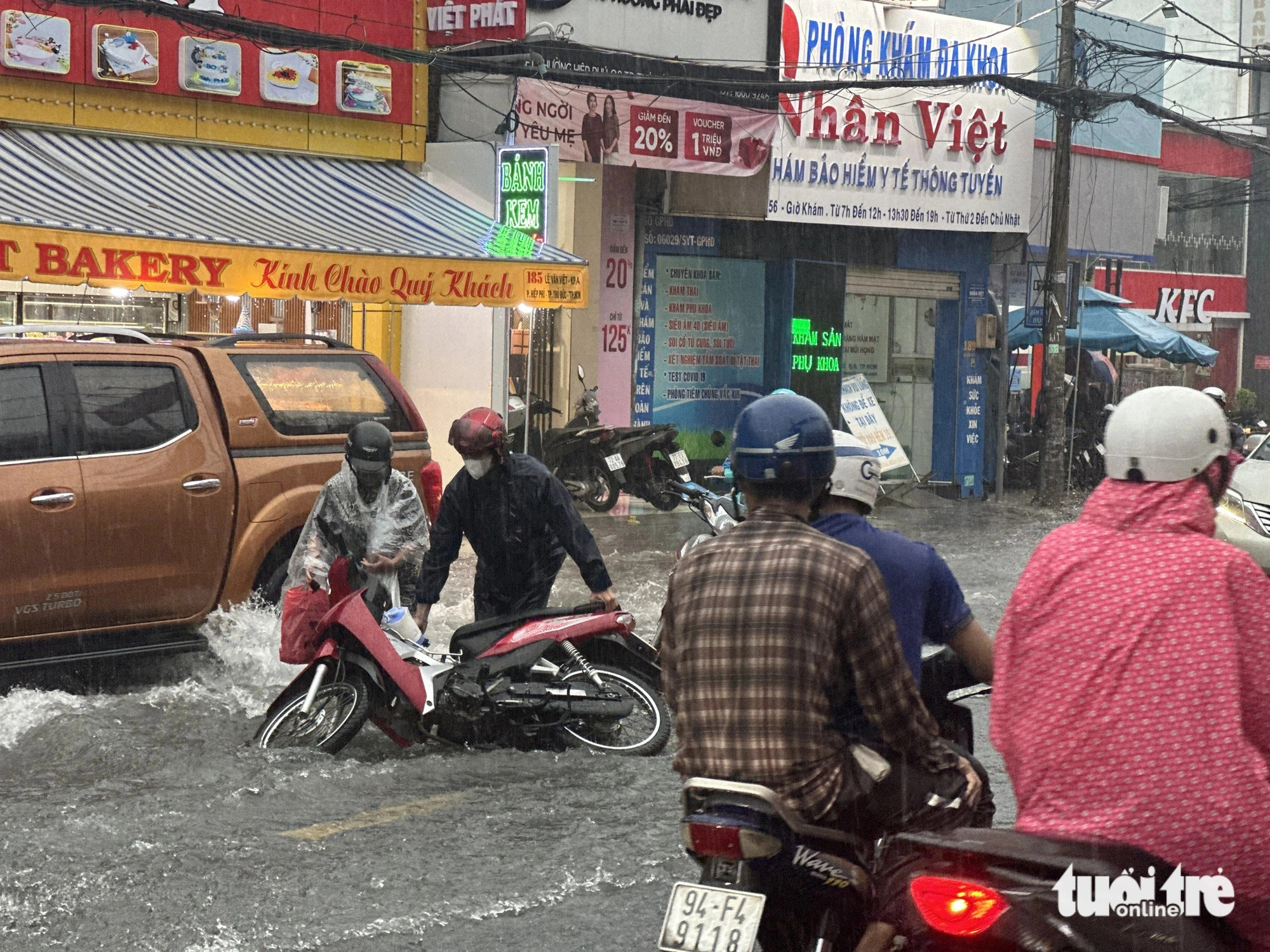 A motorcycle falls into the street due to fast-moving rainwater on Le Van Viet Street in Thu Duc City, an administrative district of Ho Chi Minh City, on May 31, 2024. Photo: Ngoc Quy / Tuoi Tre