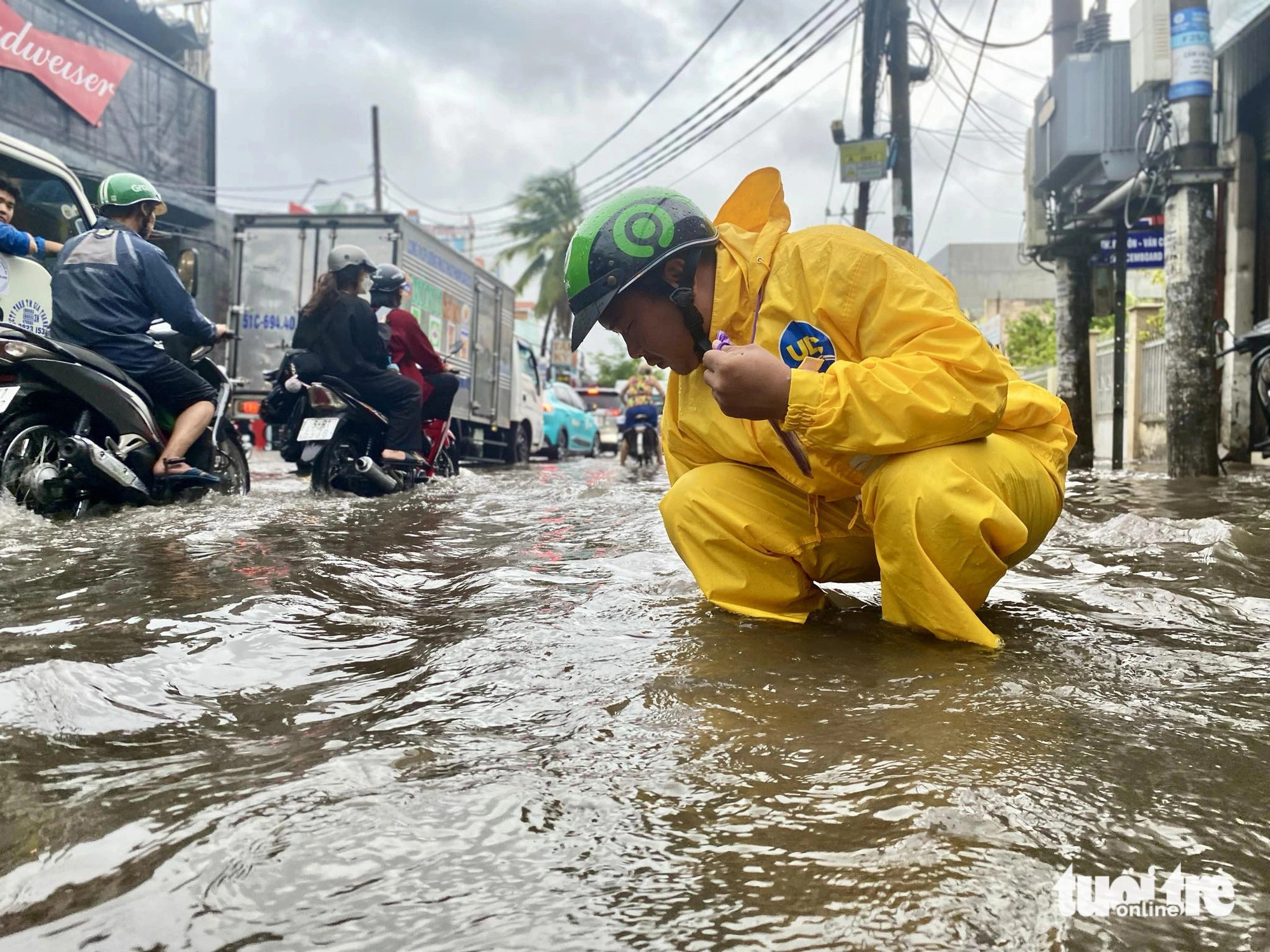 An employee of Ho Chi Minh City Urban Drainage Company removes trash from a clogged manhole to help rainwater drain quickly on a street in Ho Chi Minh City on May 31, 2024. Photo: Tien Quoc / Tuoi Tre