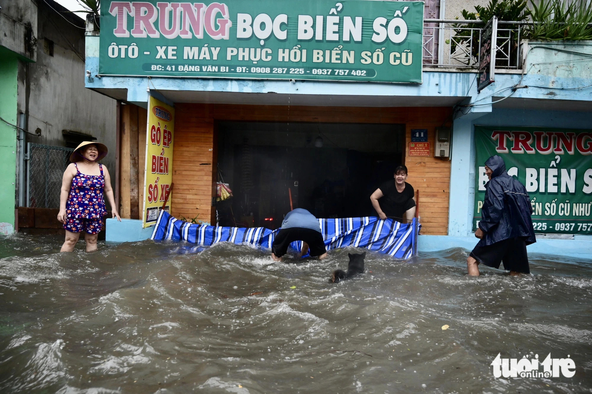 Local residents try to prevent knee-high rainwater from entering their house on Dang Van Bi Street in Thu Duc City, under the jurisdiction of Ho Chi Minh City, May 31, 2024. Photo: Phuong Quyen / Tuoi Tre