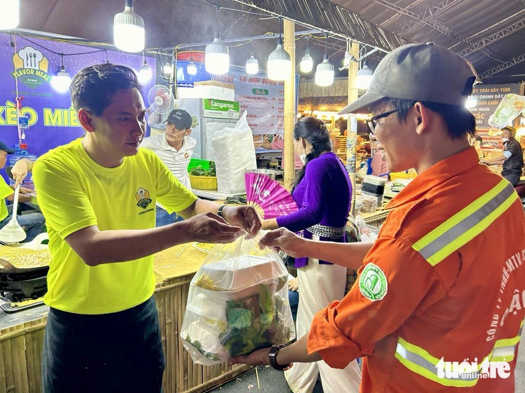 Tran Quang Khai, the owner of a food stall offering Vietnamese rice pancake at a cuisine space under the on-going Ho Chi Minh City River Festival, offers 20 free-of-charge pancakes to security guards and sanitation workers who are on duty at the food event. Photo: T.T.D / Tuoi Tre
