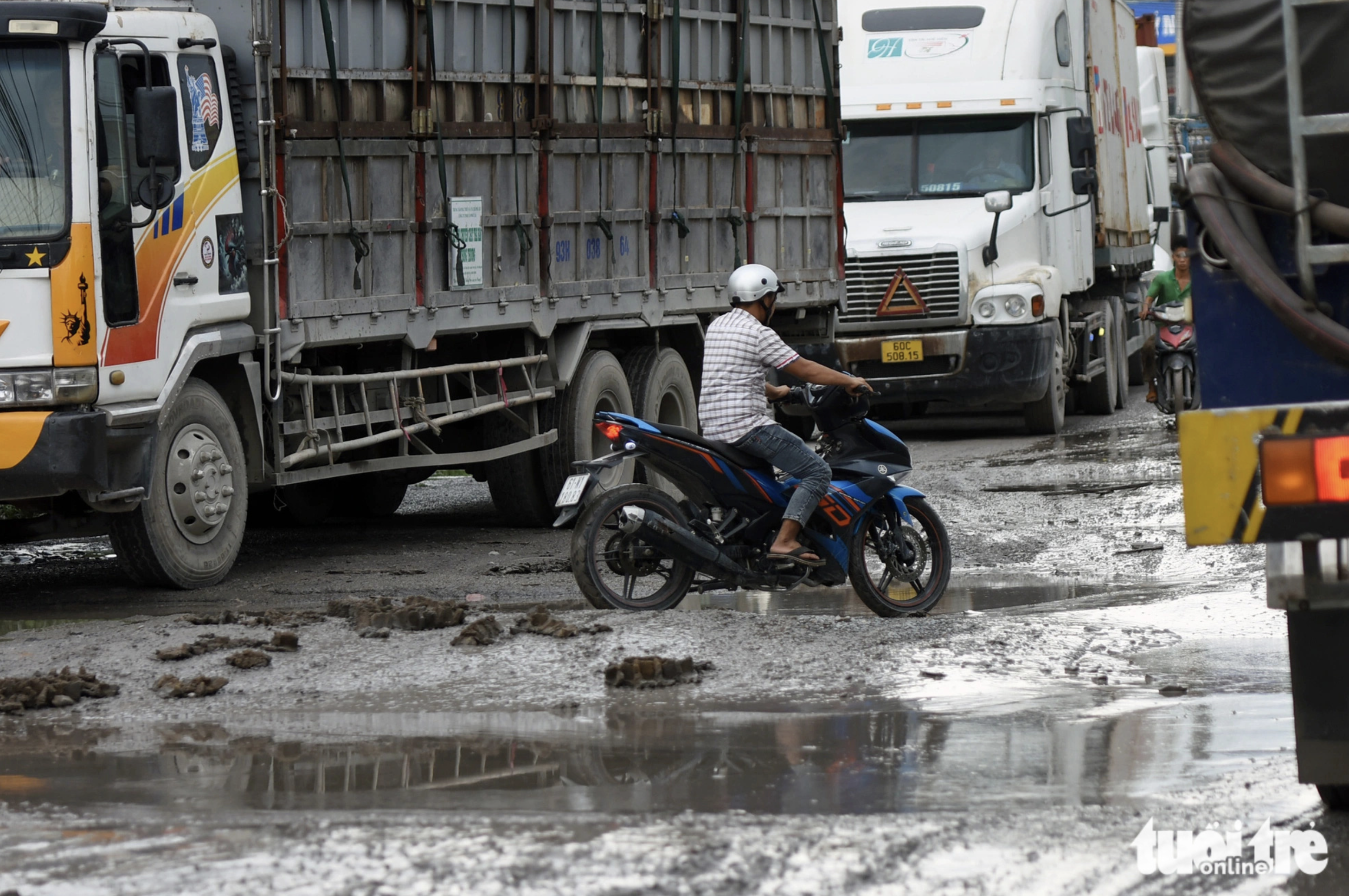 Many trucks travel on the narrow road each day, while it is filled with potholes. Photo: A Loc / Tuoi Tre