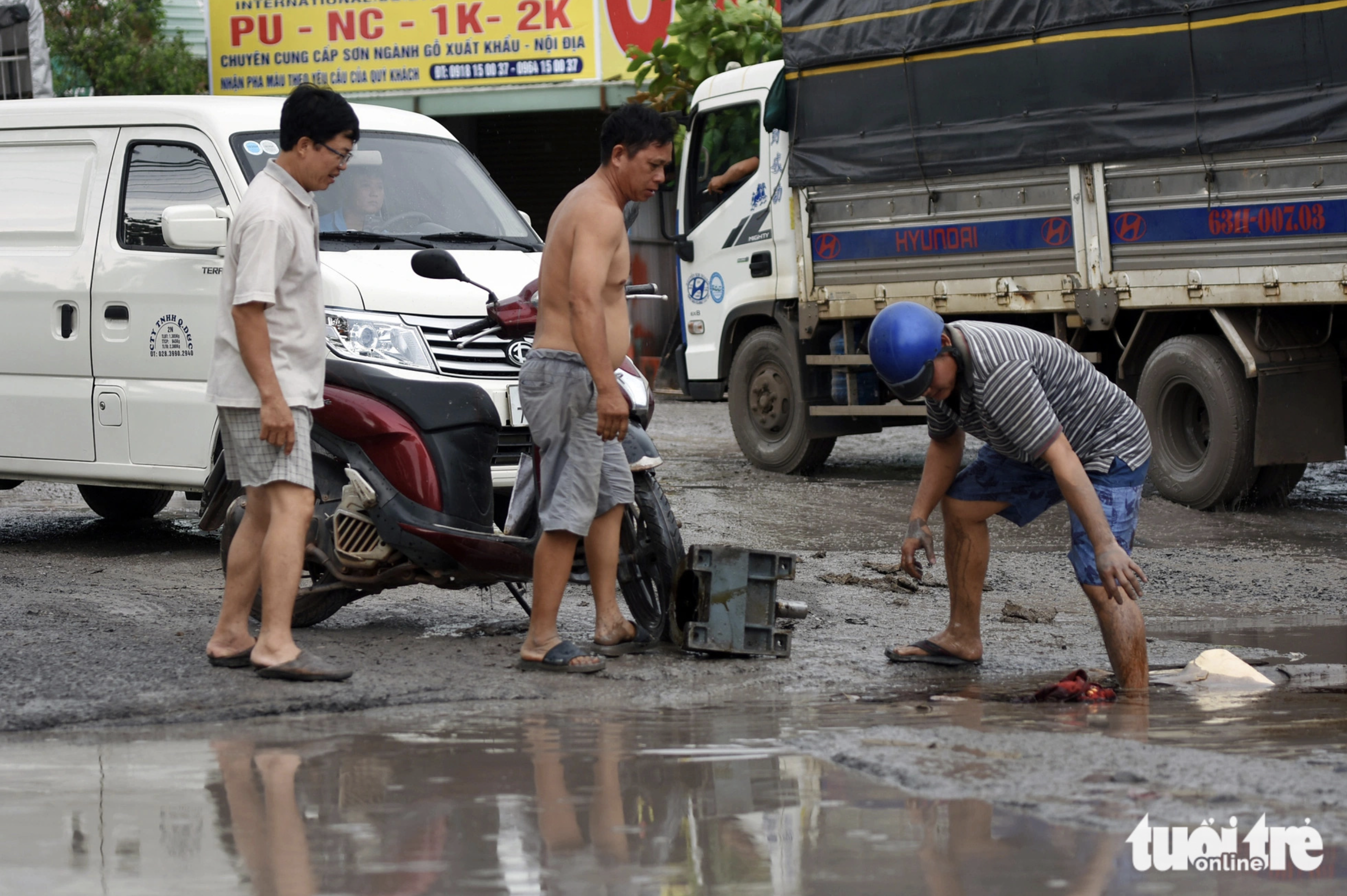 A rider hits a pothole and falls off his motorcycle. Photo: A Loc / Tuoi Tre