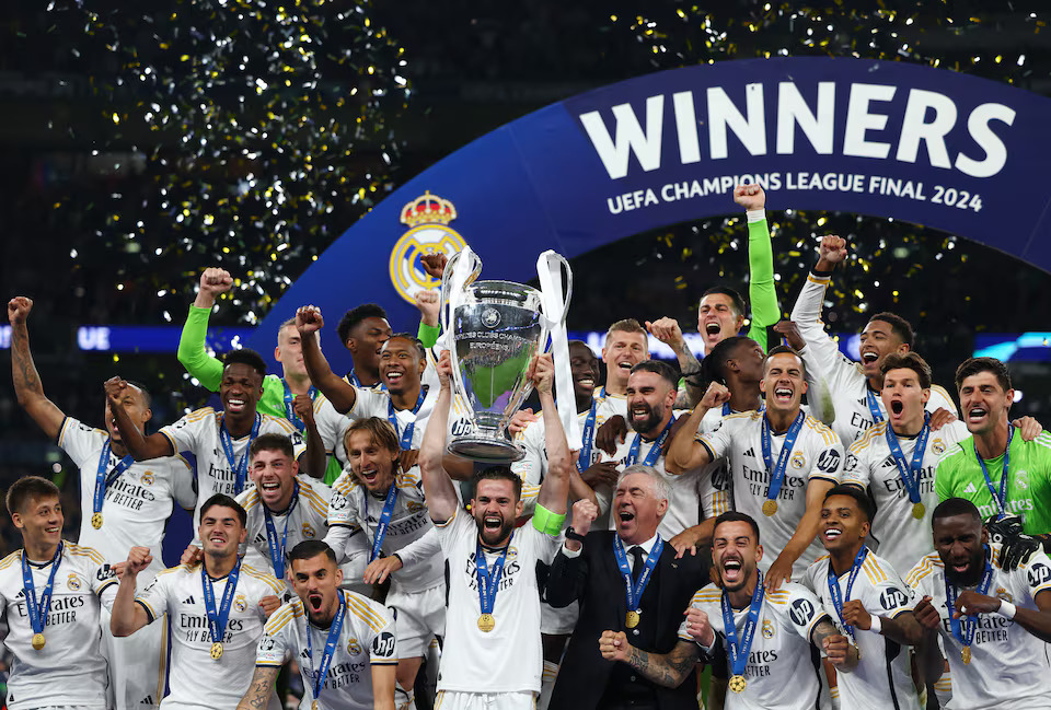 Soccer Football - Champions League - Final - Borussia Dortmund v Real Madrid - Wembley Stadium, London, Britain - June 1, 2024 Real Madrid's Dani Carvajal lifts the trophy as he celebrates with teammates and coach Carlo Ancelotti after winning the Champions League. Photo: Reuters