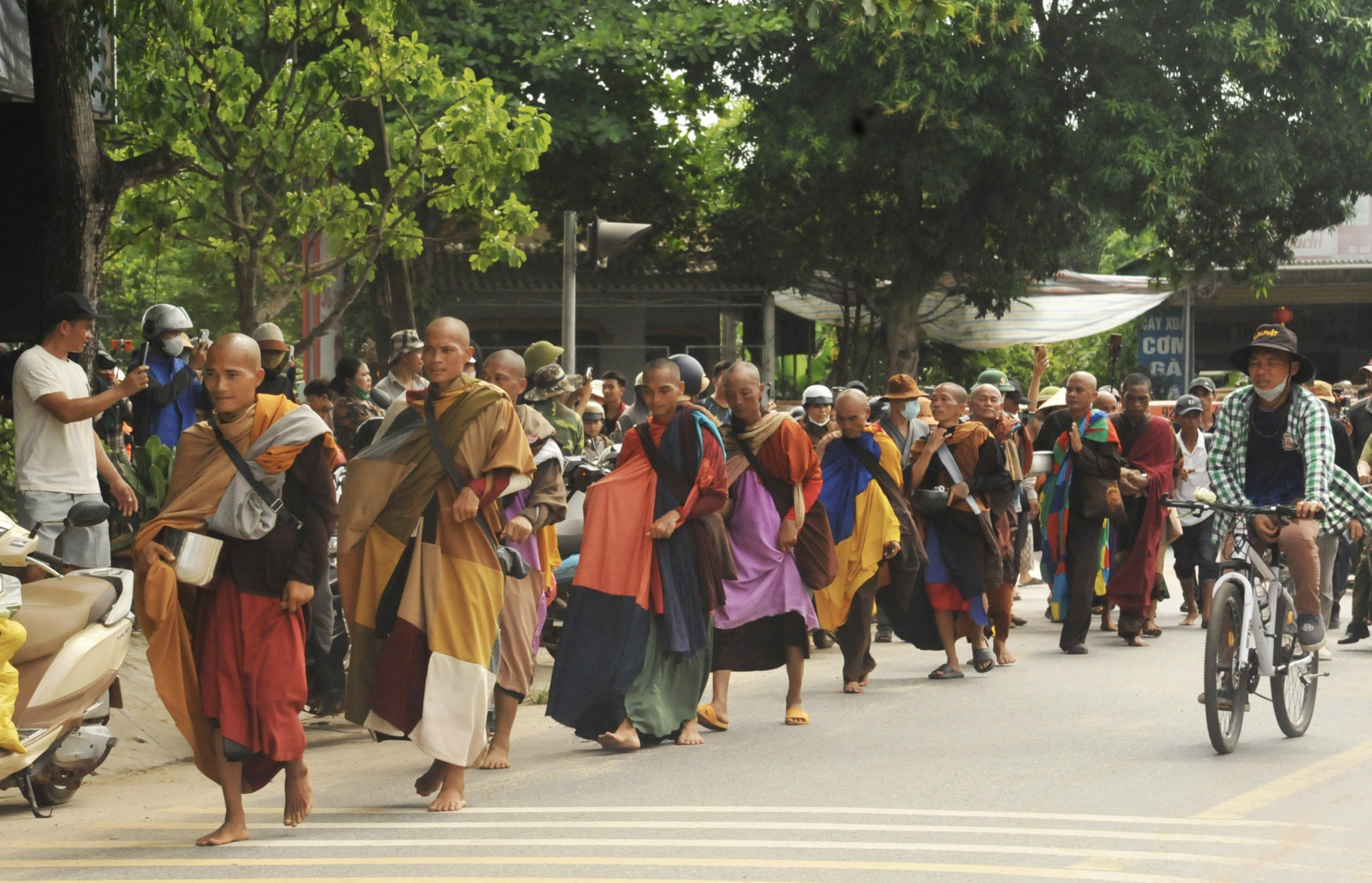 Throngs of people follow Thich Minh Tue walking on a local street in Quang Tri Province on May 28, 2024. Photo: Duc Tai / Tuoi Tre