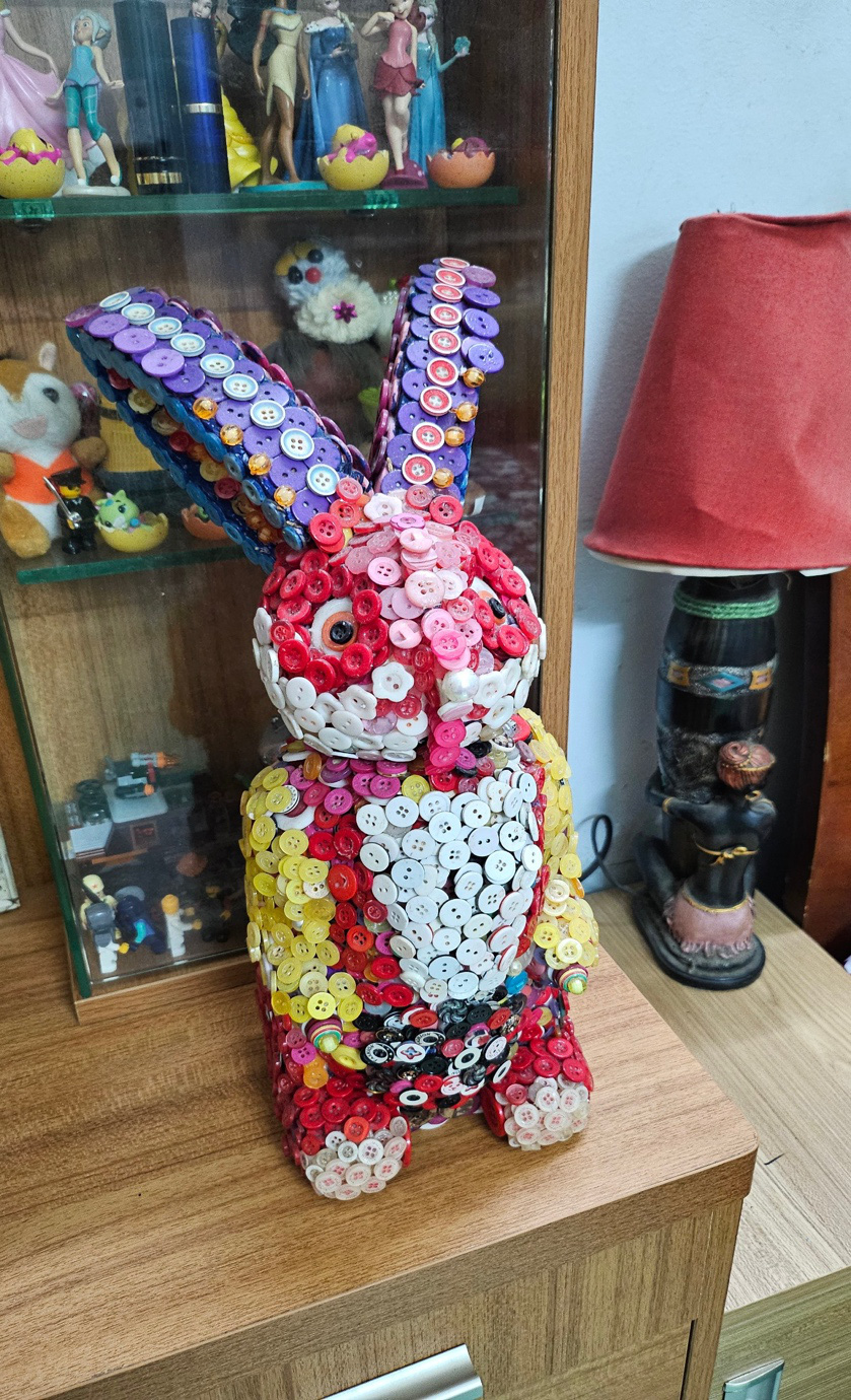 A rabbit figure made by Nguyen Phuoc Quy Thanh using old shirt buttons, plastic beads, and electric wire jackets.