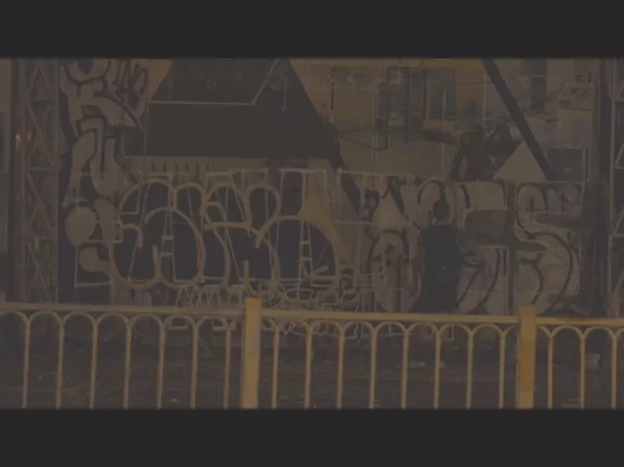 A screenshot from a video indicates the foreign man using spray paint bottles to cover blank spaces of the walls with graffiti and spray paint.