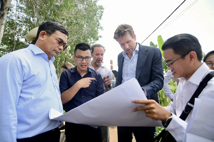 Vice mayor of Rotterdam, Netherlands Vincent Karremans (R, 2nd) looks at a sheet showing details of the flood risk management project in Thu Duc City under Ho Chi Minh City, southern Vietnam, on June 6, 2024. Photo: Quang Dinh / Tuoi Tre