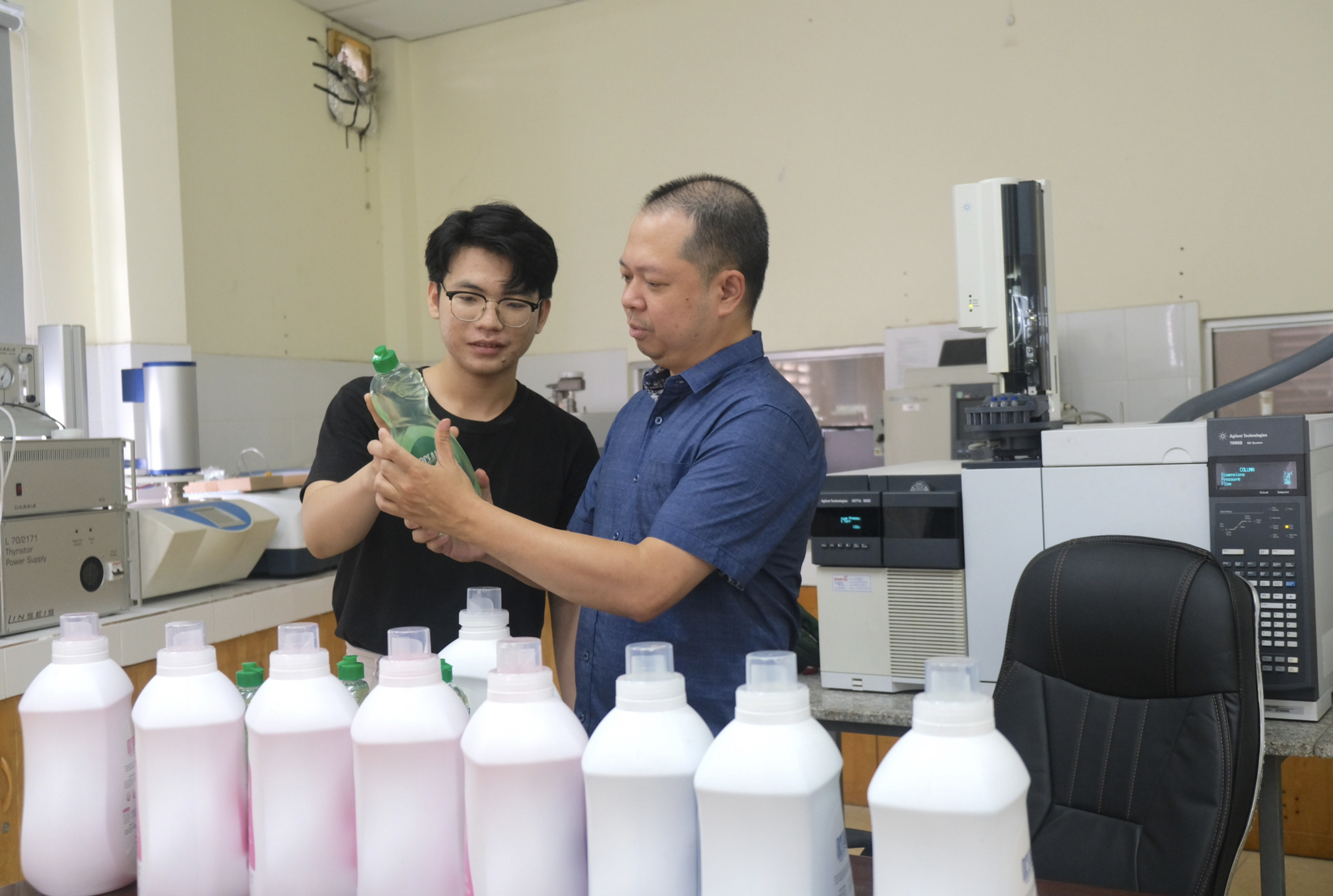 Ngo Tran Bao Viet (L), a junior at Ho Chi Minh City University of Technology, introduces detergent products made by him to Associate Prof. Dr. Nguyen Dinh Quan. Photo: Ngoc Phuong / Tuoi Tre