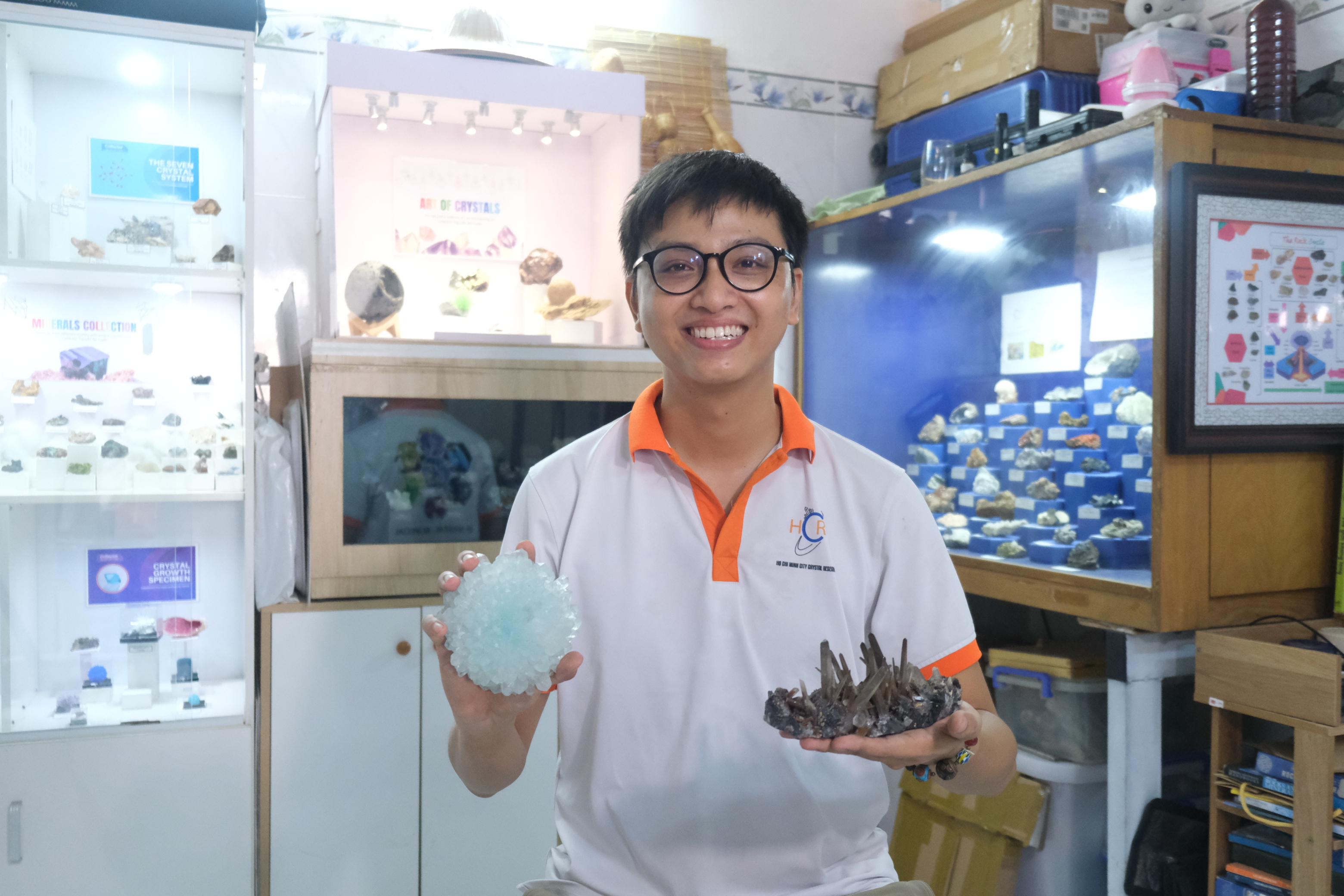Nguyen Ba Tuyen poses with two pieces of crystals with his collection in the background at his home in Ho Chi Minh City. Photo: Ngoc Phuong / Tuoi Tre News