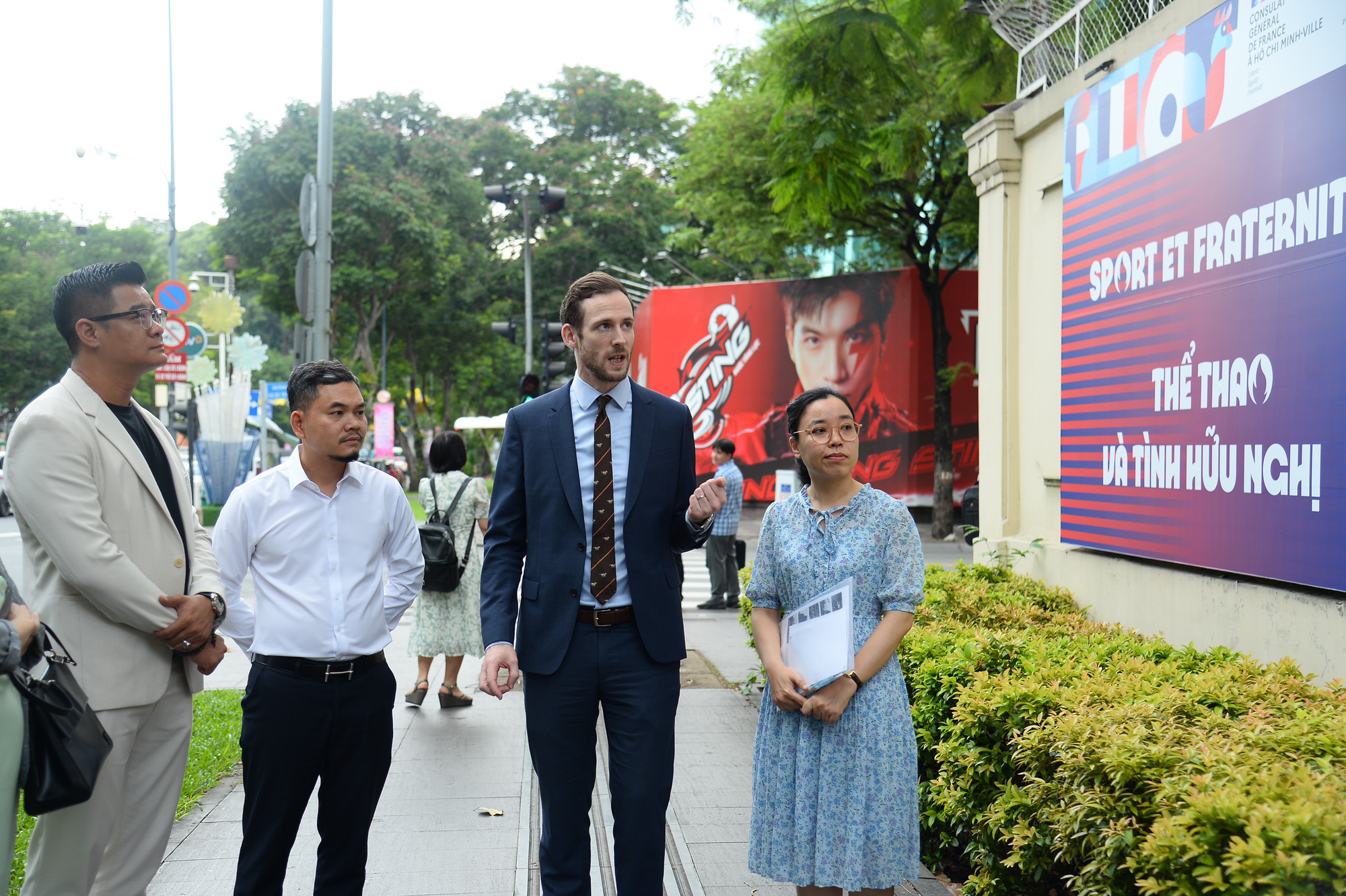 Deputy Consul General of France in Ho Chi Minh City, Grégory Robert (R, 2nd), introduces the ‘Sports and Fraternity’ exhibition to visitors outside the French Residence on Le Duan Street in District 1, Ho Chi Minh City, June 11, 2024. Photo: Hai Quynh / Tuoi Tre