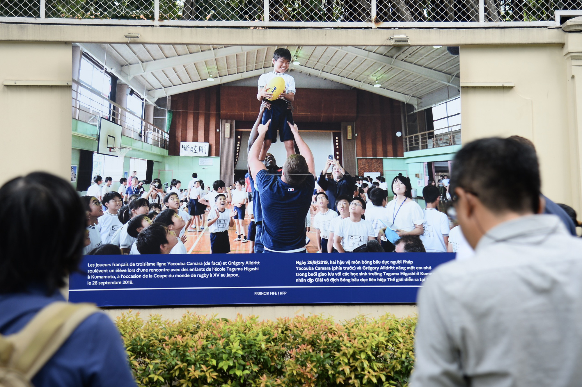 A photo depicts two French rugby defenders lifting a child during an interaction with students from Taguma Higashi School in Kumamoto, on the occasion of the Rugby Union World Cup in Japan. Photo: Hai Quynh / Tuoi Tre