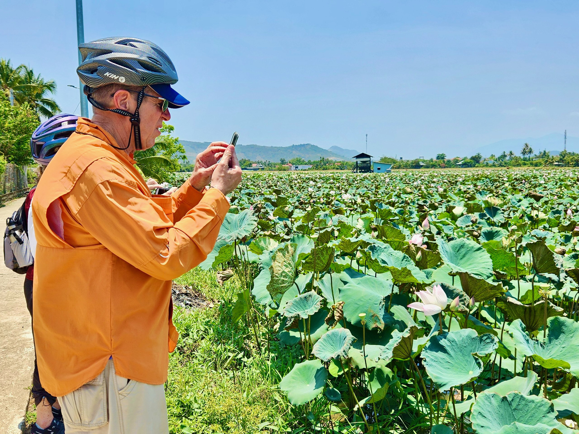 A foreign tourist takes photos of a lotus pond in Nha Trang City, Khanh Hoa Province, south-central Vietnam. Photo: Minh Chien / Tuoi Tre