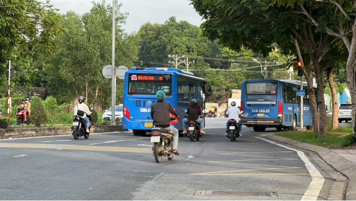 A bus of route No. 8 and a bus of route No. 99 queue up to jump a red light. Photo: Xuan Doan / Tuoi Tre