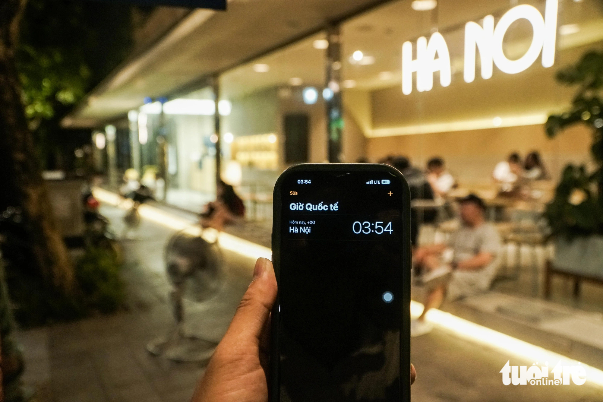 A smartphone shows the time is 3:54 am when a coffee shop is filled with customers on Tong Dan Street in Hoan Kiem District, Hanoi, June 14, 2024. Photo: Pham Tuan / Tuoi Tre