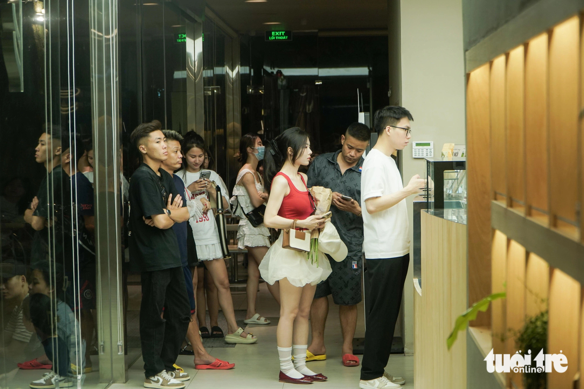 Customers line up at the order counter at a coffee shop on Tong Dan Street in Hoan Kiem District, Hanoi, at dawn on June 14, 2024. Photo: Pham Tuan / Tuoi Tre