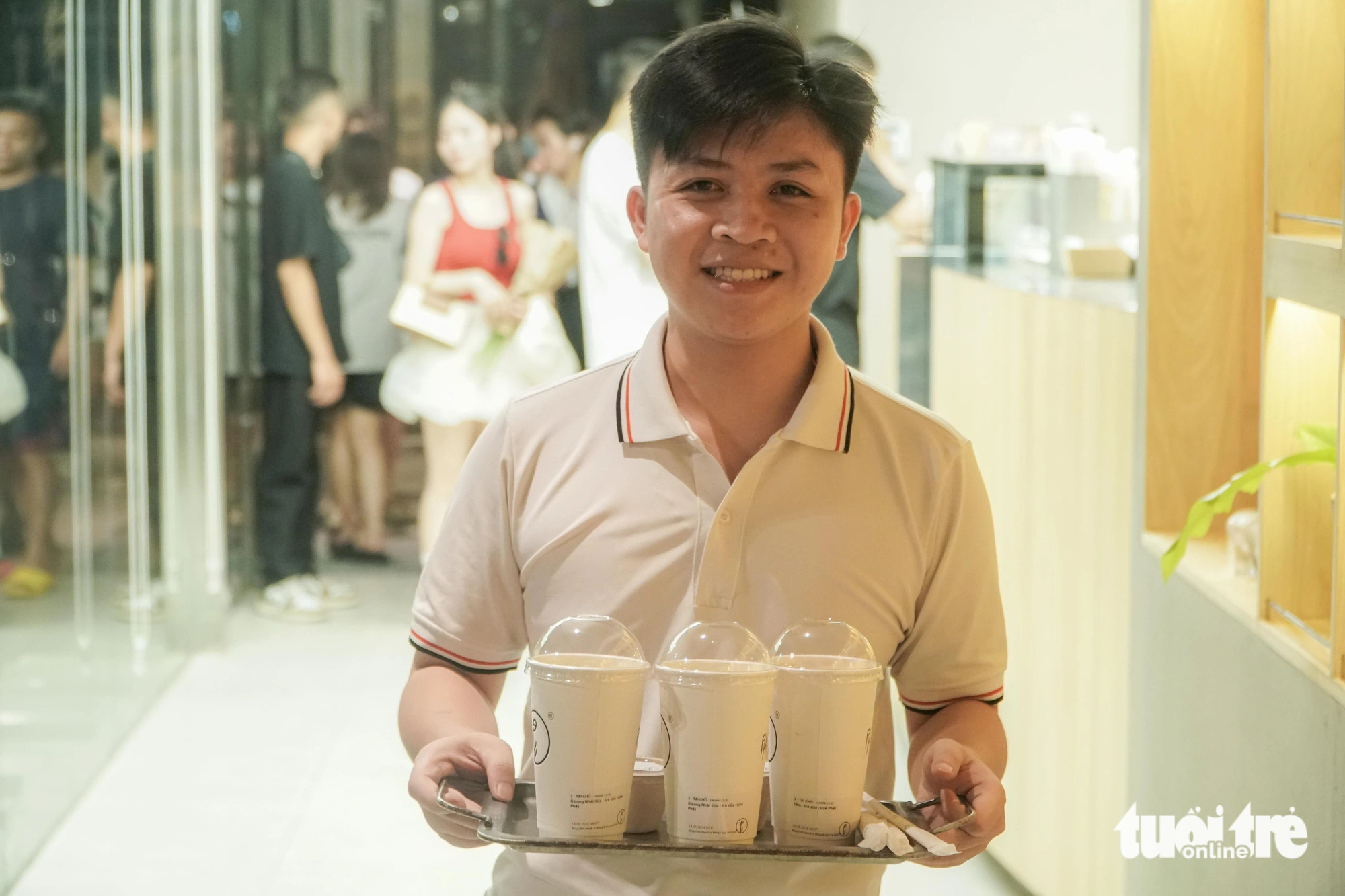 Nguyen The Hien receives his order at a coffee shop on Tong Dan Street in Hoan Kiem District, Hanoi, at dawn on June 14, 2024. Photo: Pham Tuan / Tuoi Tre