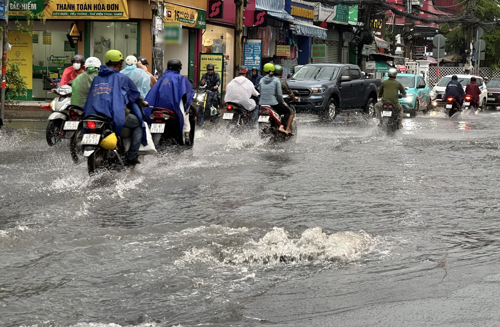 Road users make their way to get through flood-hit Le Van Viet Street in Thu Duc City under the jurisdiction of Ho Chi Minh City due to heavy rainfall on June 14, 2024. Photo: Ngoc Quy / Tuoi Tre