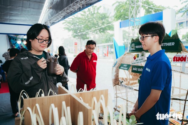 A young person exchanges recyclable trash for a gift at the Green Vietnam pavilion. Photo: Thanh Hiep / Tuoi Tre