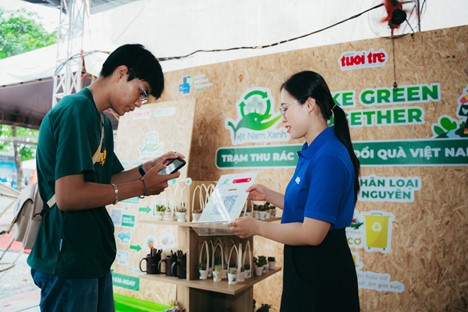 A young man scans a QR code at the Green Vietnam pavilion to spread the message of “Make Green Together”. Photo: Thanh Hiep / Tuoi Tre