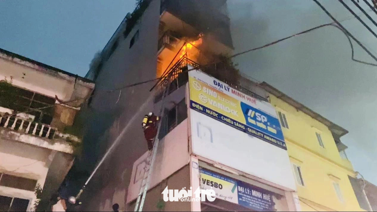 Firefighters use a ladder to approach the burning floor of a five-story house in Hoang Mai District, Hanoi on June 16, 2024. Photo: Danh Khang / Tuoi Tre