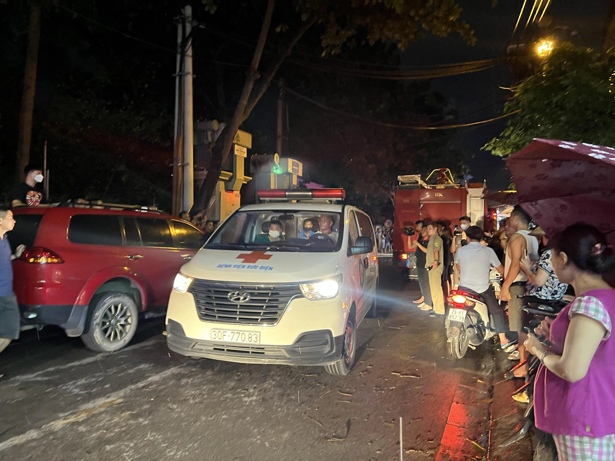 An ambulance leaves the scene of the house fire at 9:20 pm on June 16, 2024. Photo: Danh Khang / Tuoi Tre