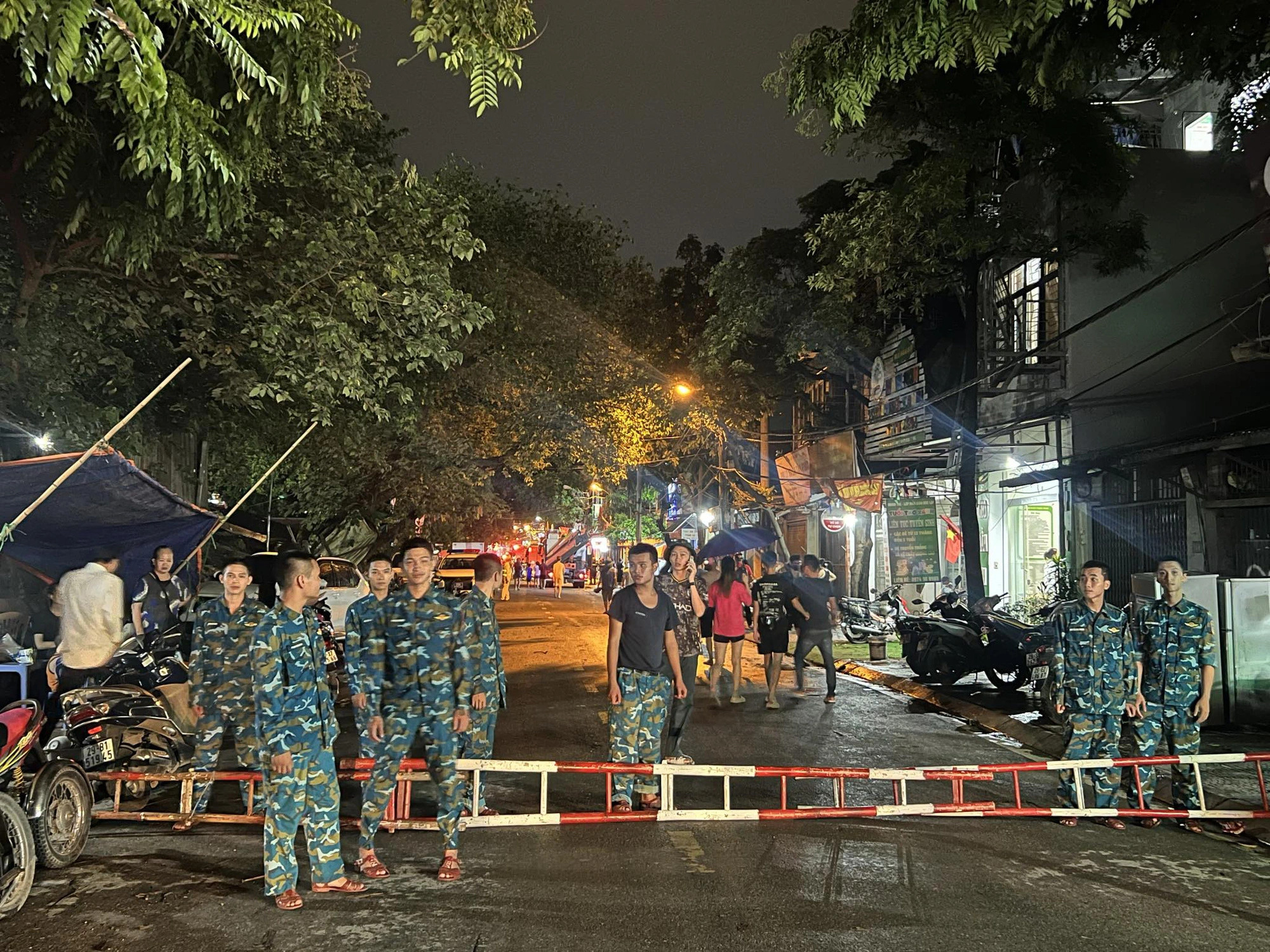 Soldiers cordon off a road section near the scene of the house fire. Photo: Danh Trong / Tuoi Tre