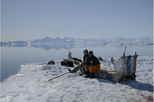 Greenland's greatest Inuit polar bear hunter Hjelmer Hammeken (L) and his young protege Martin Madsen out on the ice.