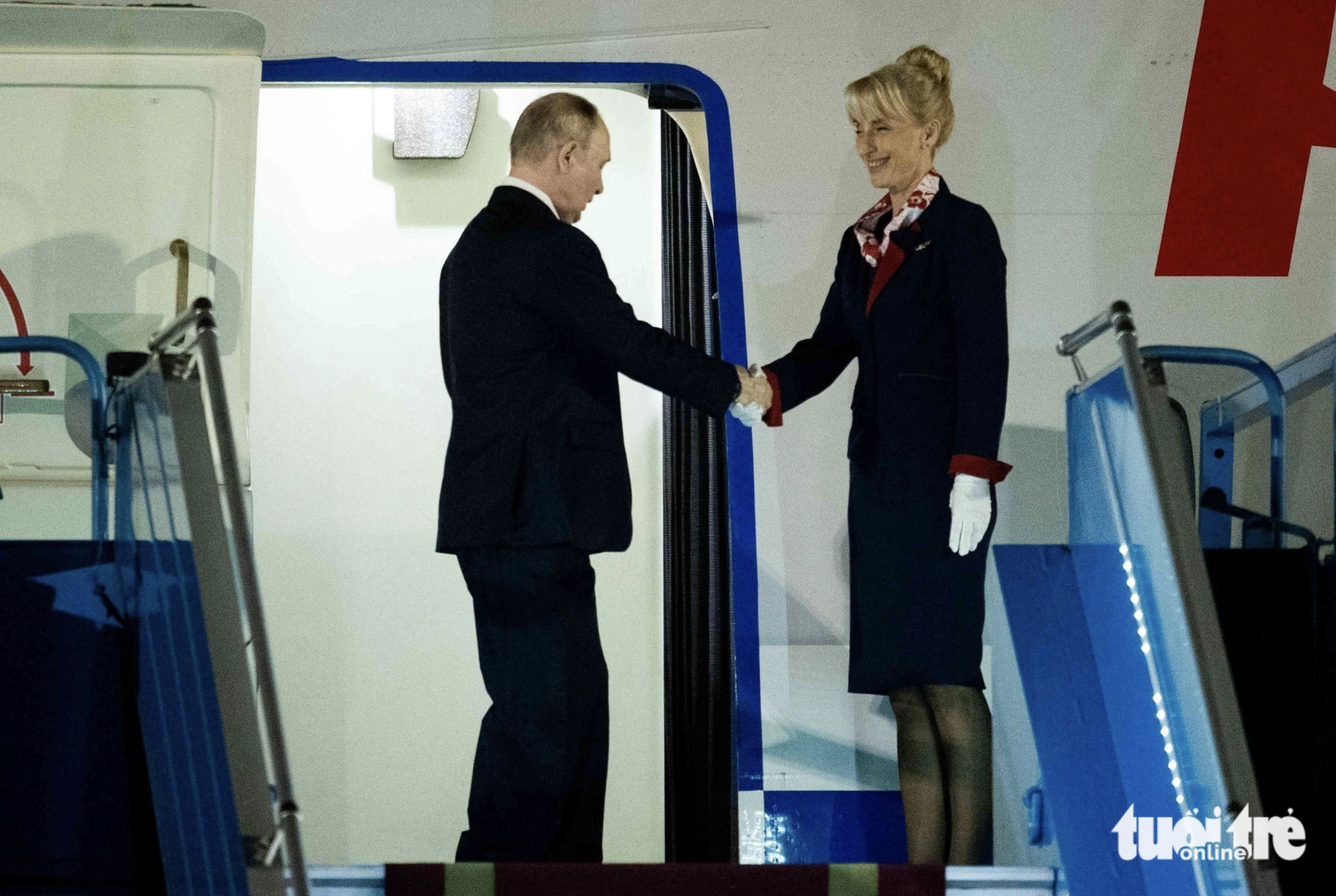 Russian President Putin (L) shakes hands with an aircraft crew staffer. Photo: Nguyen Khanh / Tuoi Tre