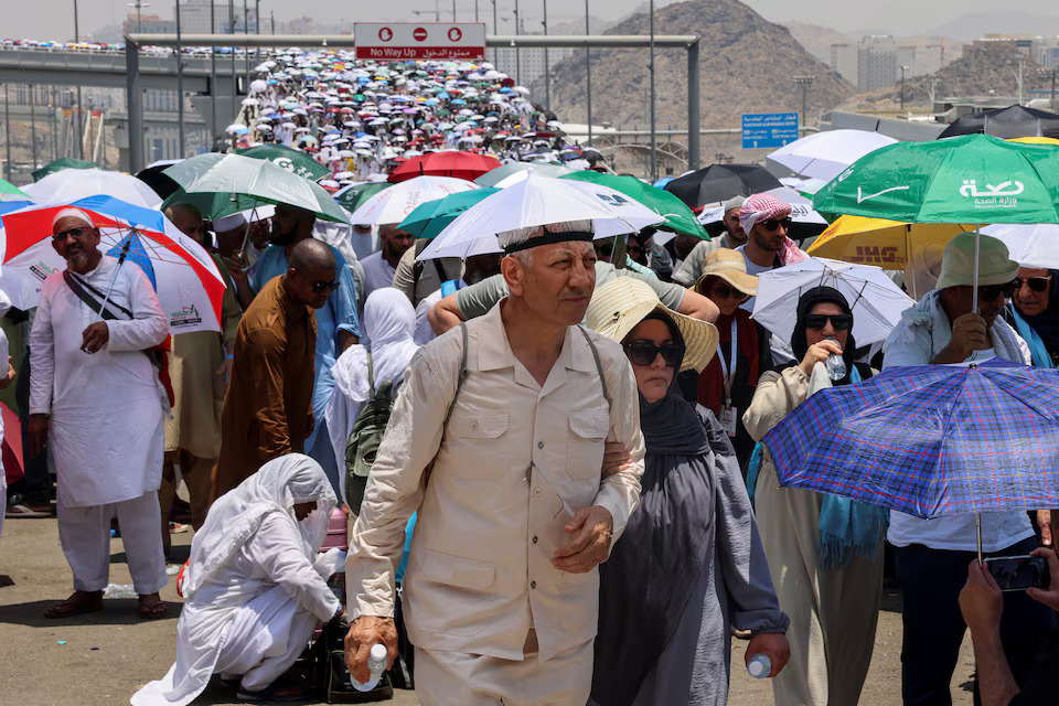 Muslim pilgrims walk with umbrellas on the third day of the Satan stoning ritual, amid extremely hot weather, during the annual haj pilgrimage, in Mina, Saudi Arabia, June 18. Photo: Reuters