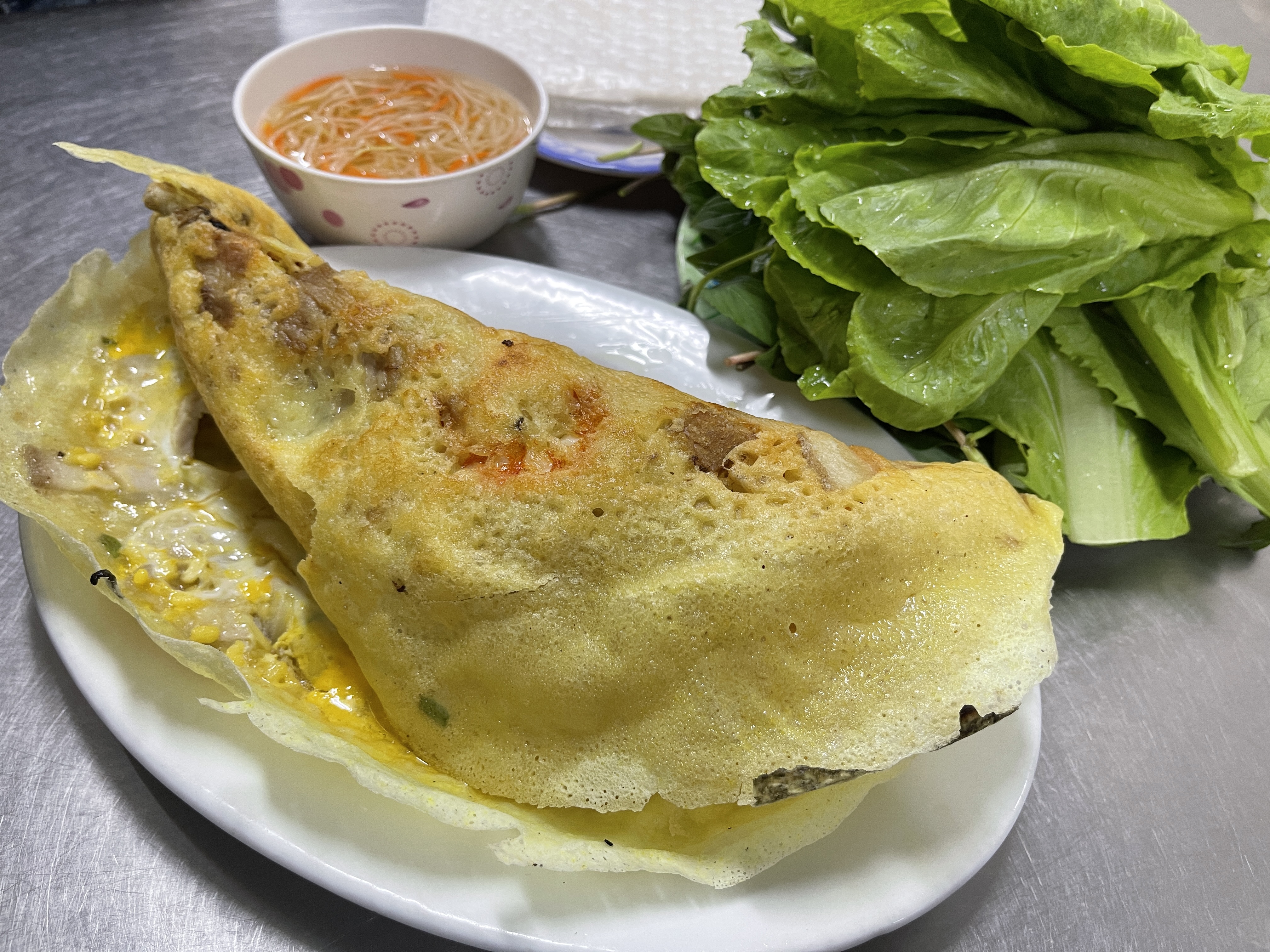 'Bánh xèo' (Vietnamese sizzling crepes) is served with veggies and fish sauce at Bánh Xèo 46A in District 1, Ho Chi Minh City. Photo: Dong Nguyen / Tuoi Tre News