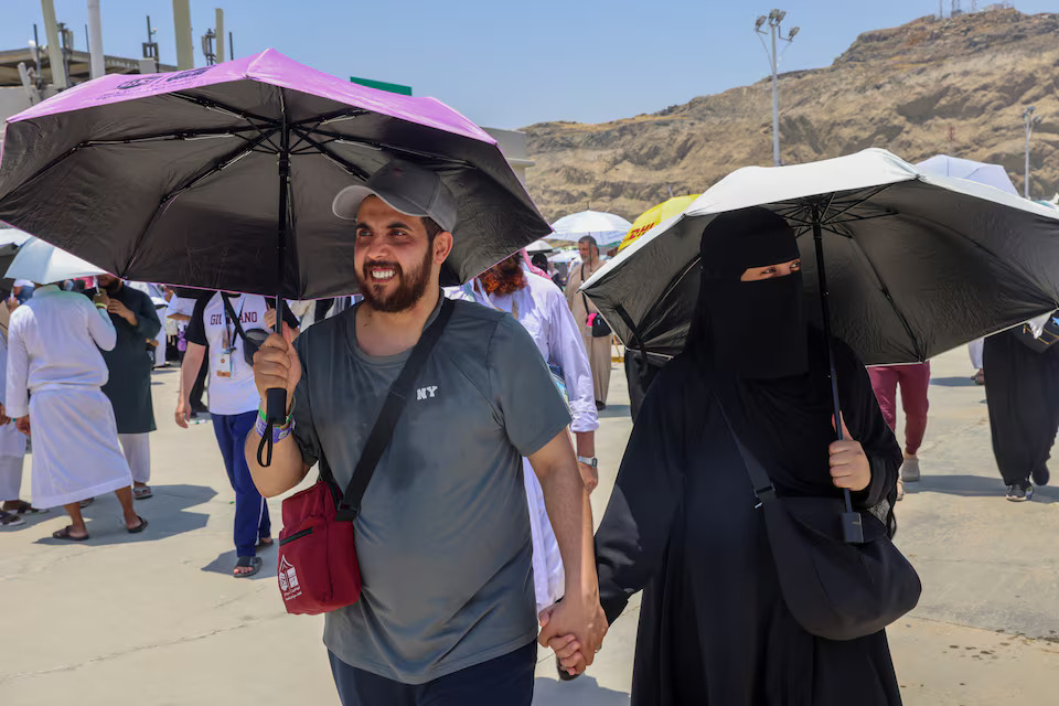 [10/42]A Muslim pilgrim couple hold hands as they walk with umbrellas at site of the Satan stoning, amid extremely hot weather, during the annual haj pilgrimage in Mina, Saudi Arabia June 18.  Photo: Reuters