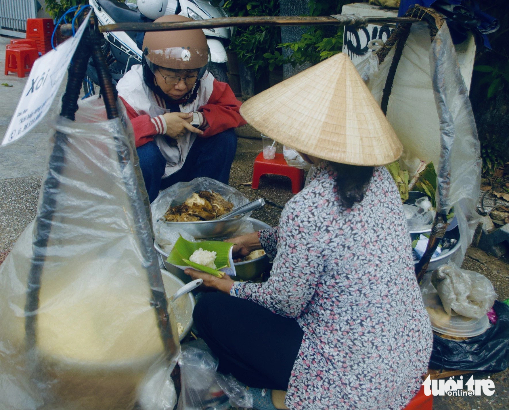 Le sells chicken sticky rice from her bamboo baskets. Photo: Ho Lam / Tuoi Tre