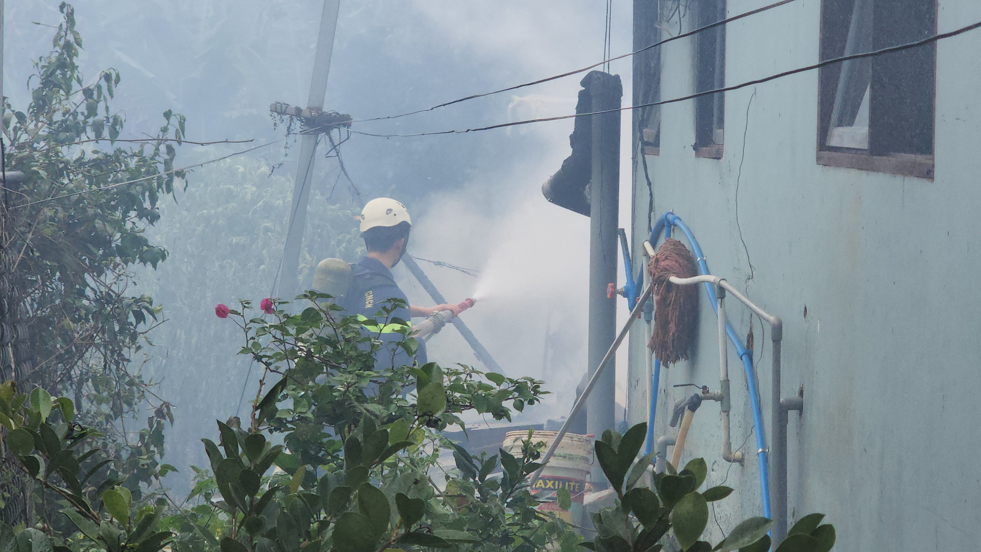 A firefighter extinguishes a house fire that claimed three children on Nguyen Phi Y Lan Street in Ward 7, Da Lat City, Lam Dong Province, Vietnam. Photo: M.V. / Tuoi Tre